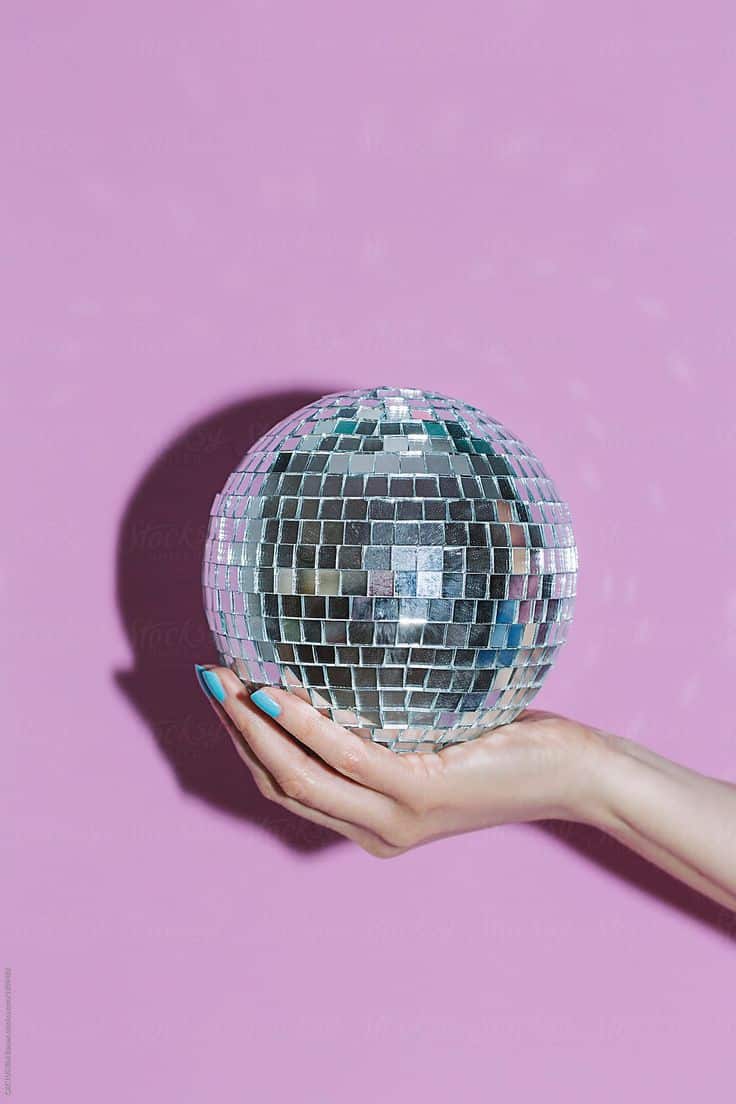 hand holding a disco ball by stocksy contributor cactus creative studio (1)